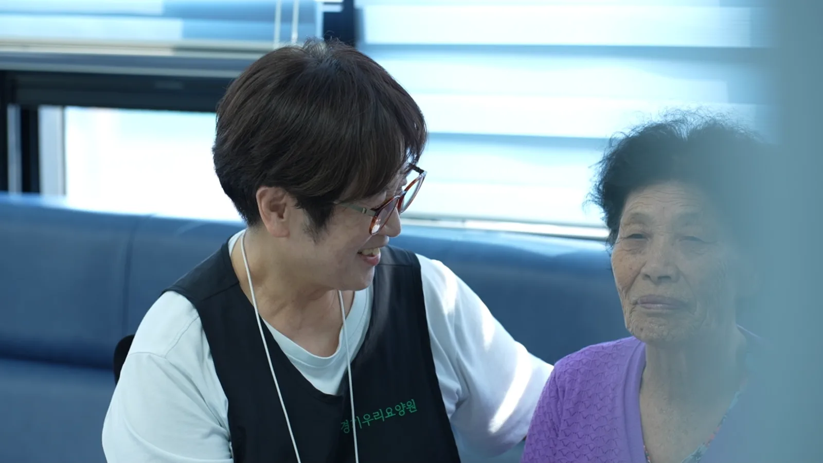 경기우리요양원 직원이 어르신 곁에서 이야기를 나누는 모습